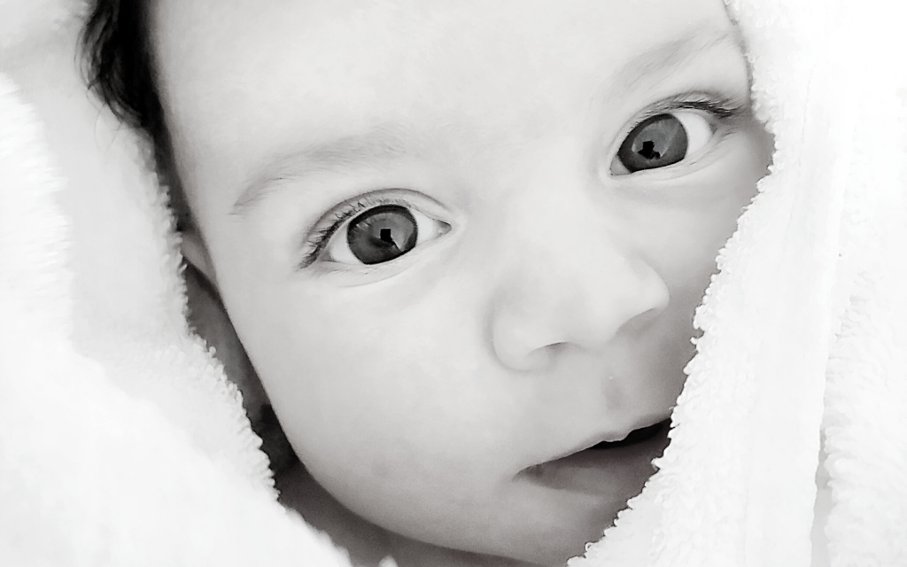 A closeup image of a baby's boy face. 