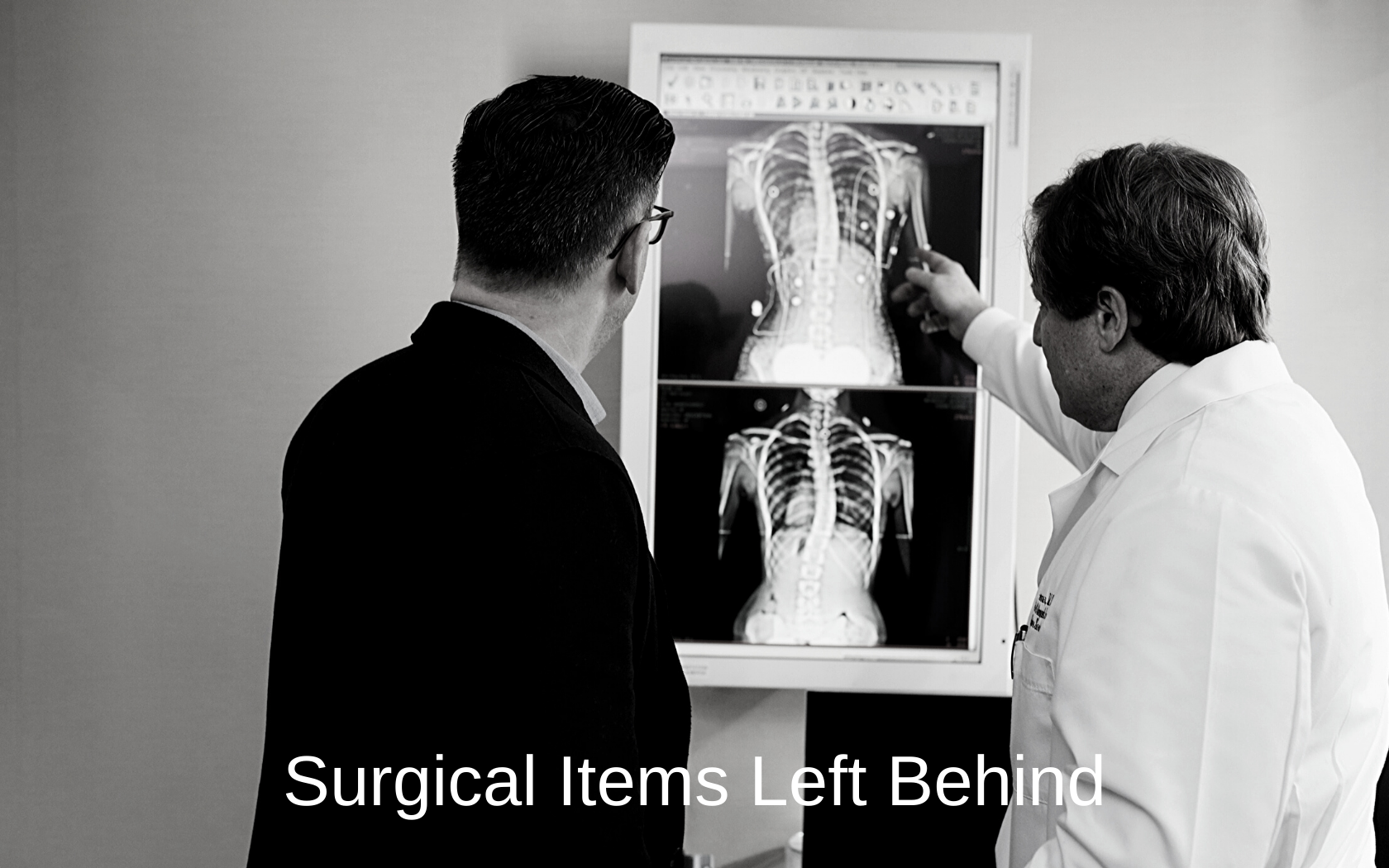 A doctor looks at an x-ray while explaining something to a patient.