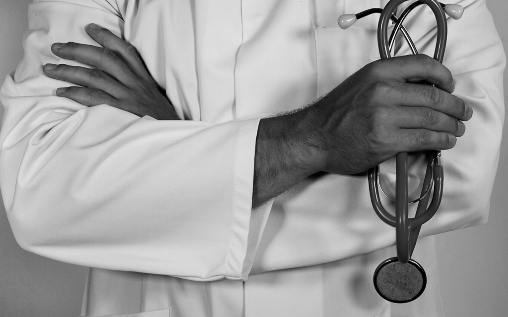 Doctor stands with arms folded while holding a stethoscope