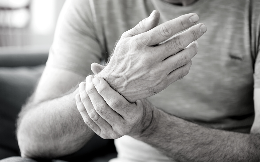 Man with nerve pain holding his wrist.