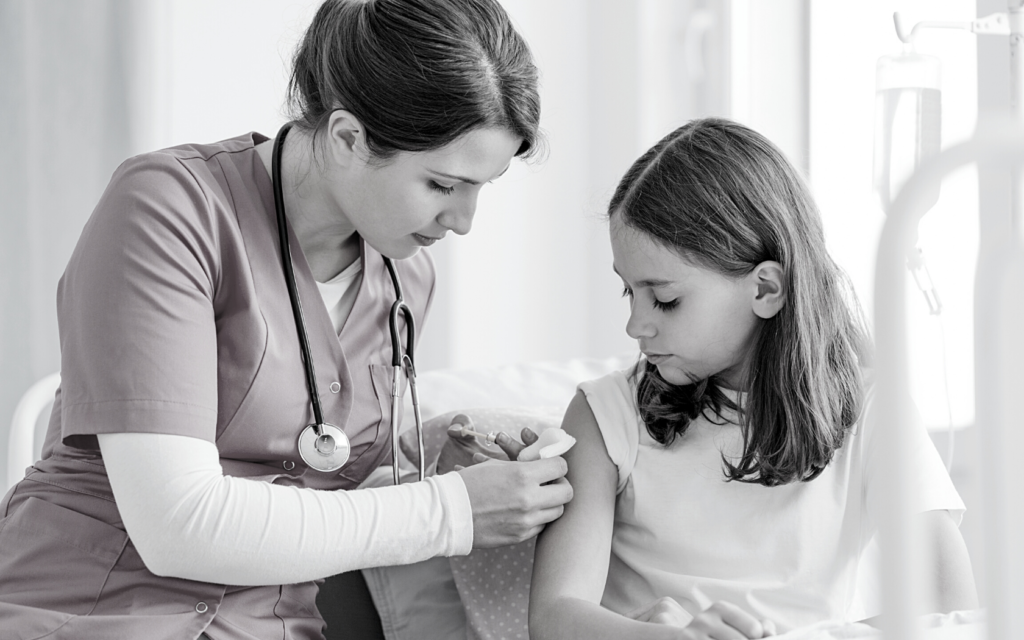 Pediatric nurse gives shot to child.