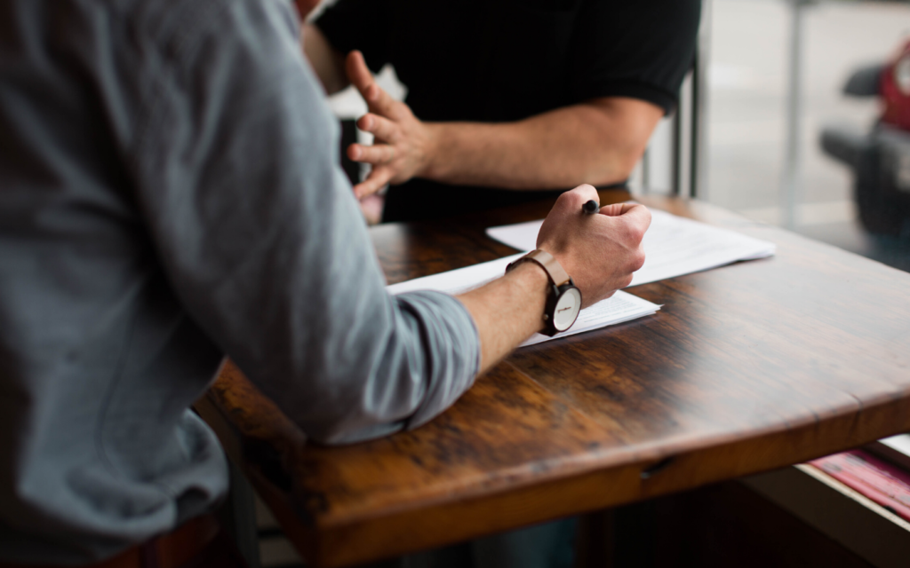 Two people discuss a legal situation with a document in hand.