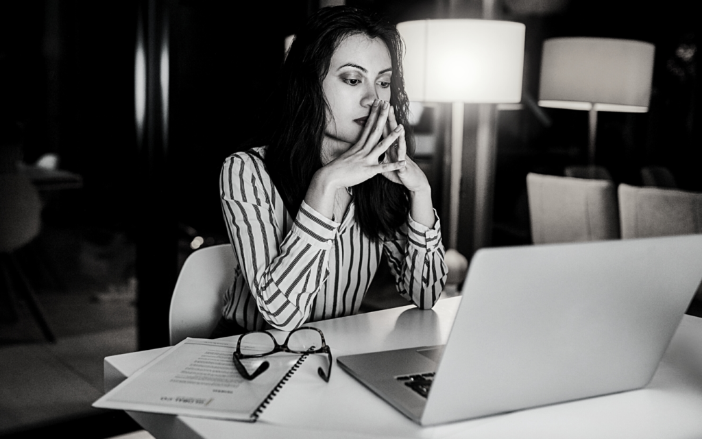 Woman looking at a laptop, searching online for a medical lawyer. 