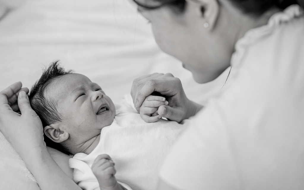 Mother comforts baby with Erb's palsy.