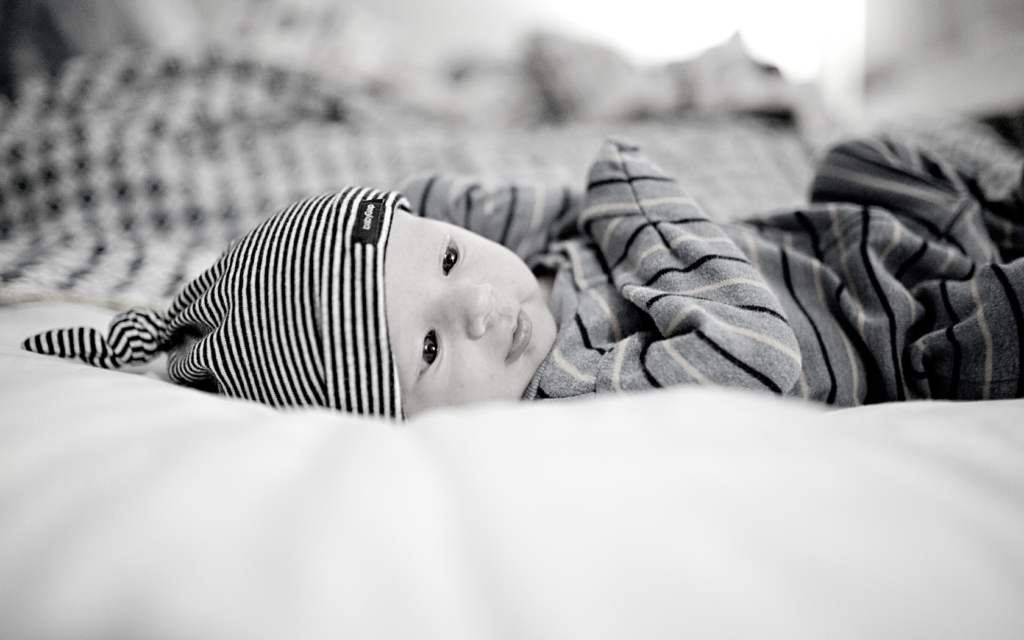 Newborn baby boy laying on blanket.