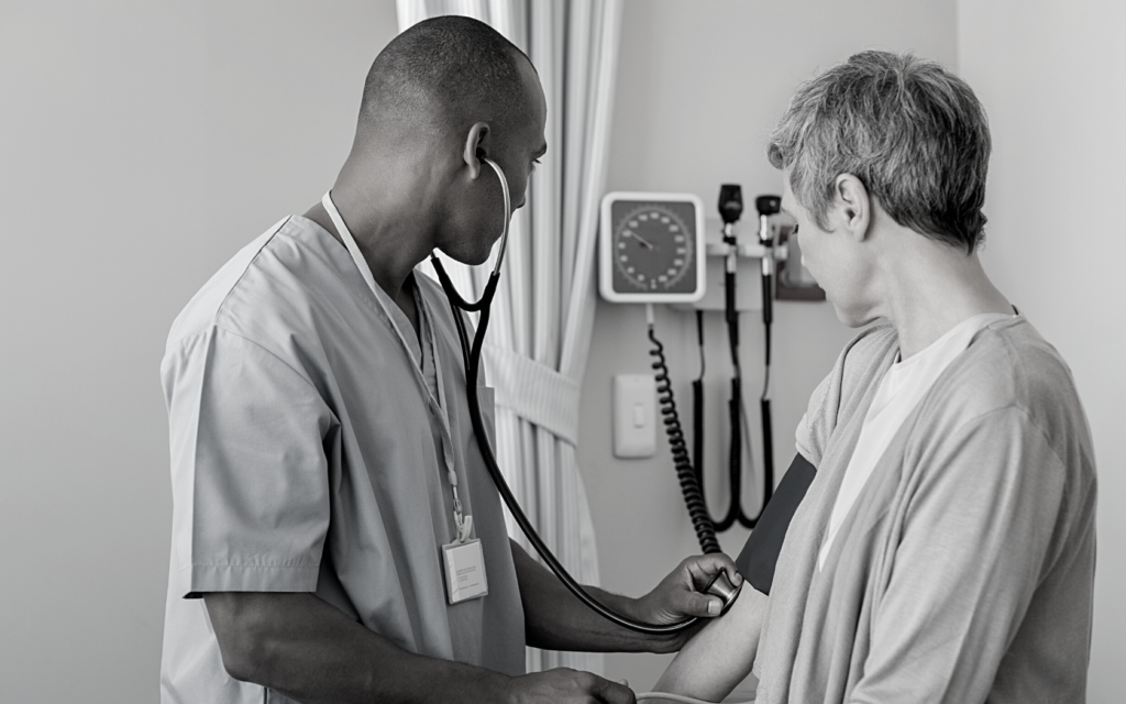 Male nurse treats older female patient. 