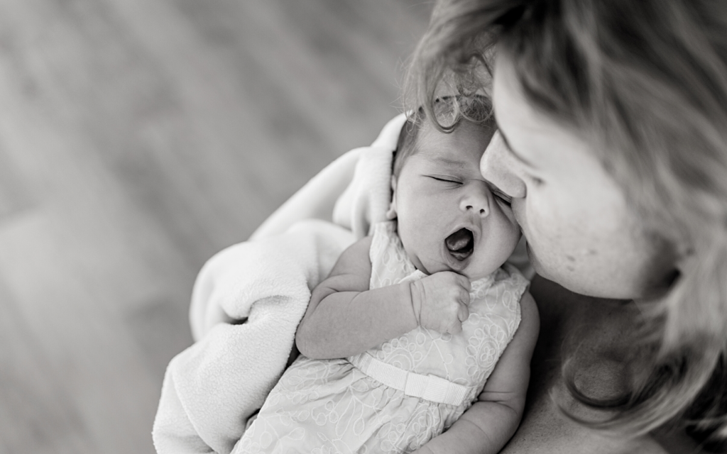 Mother holds her baby girl close.