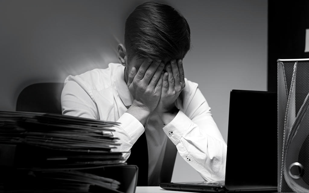 Photo of doctor holding his head in his hands, implying he has made a negligent error.