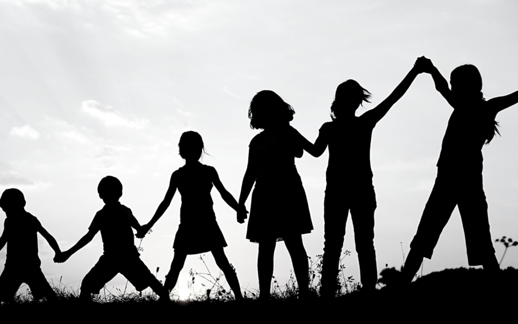 A group of children holding hands and supporting one another.
