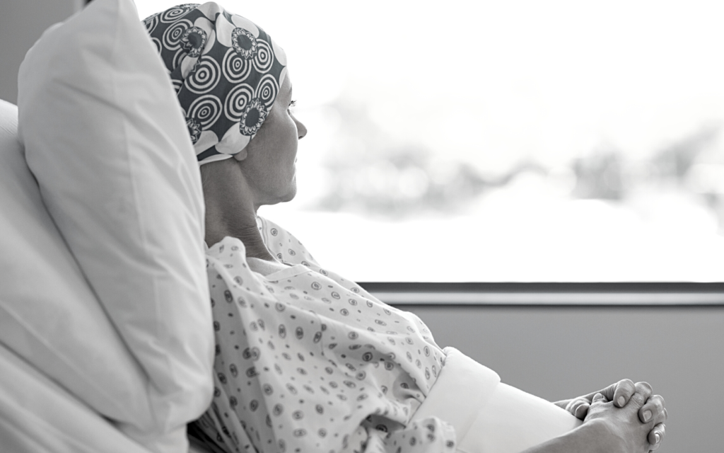 Cancer patient stares out hospital window.