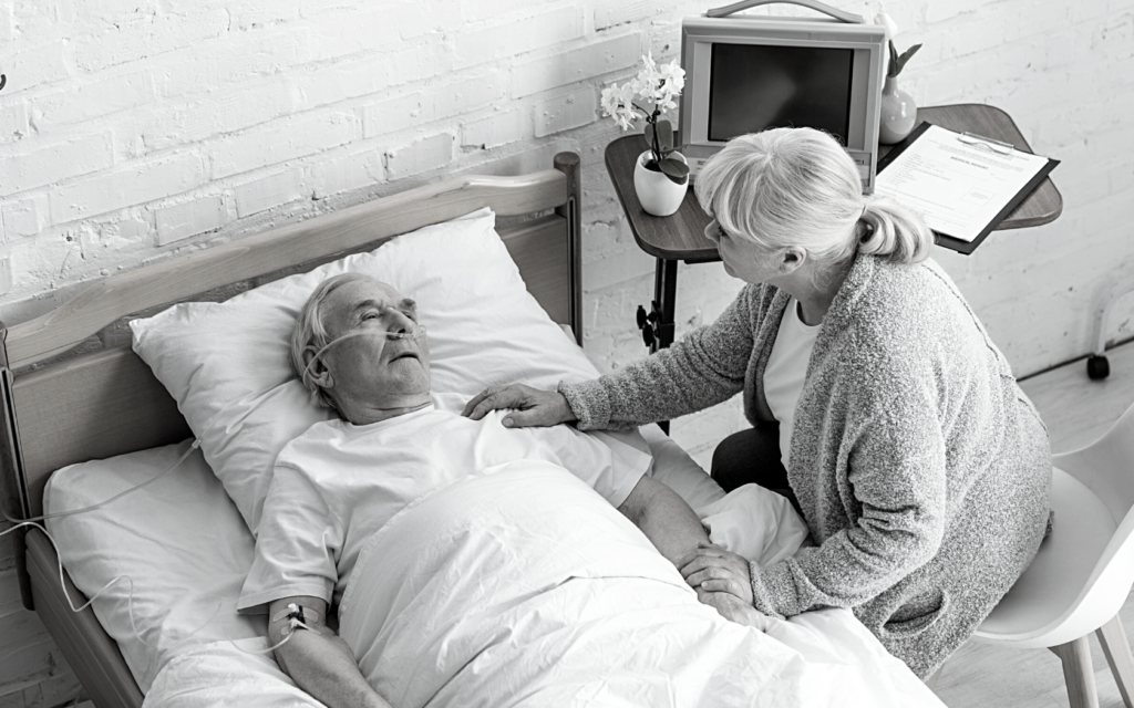 Elderly patient being comforted by wife.