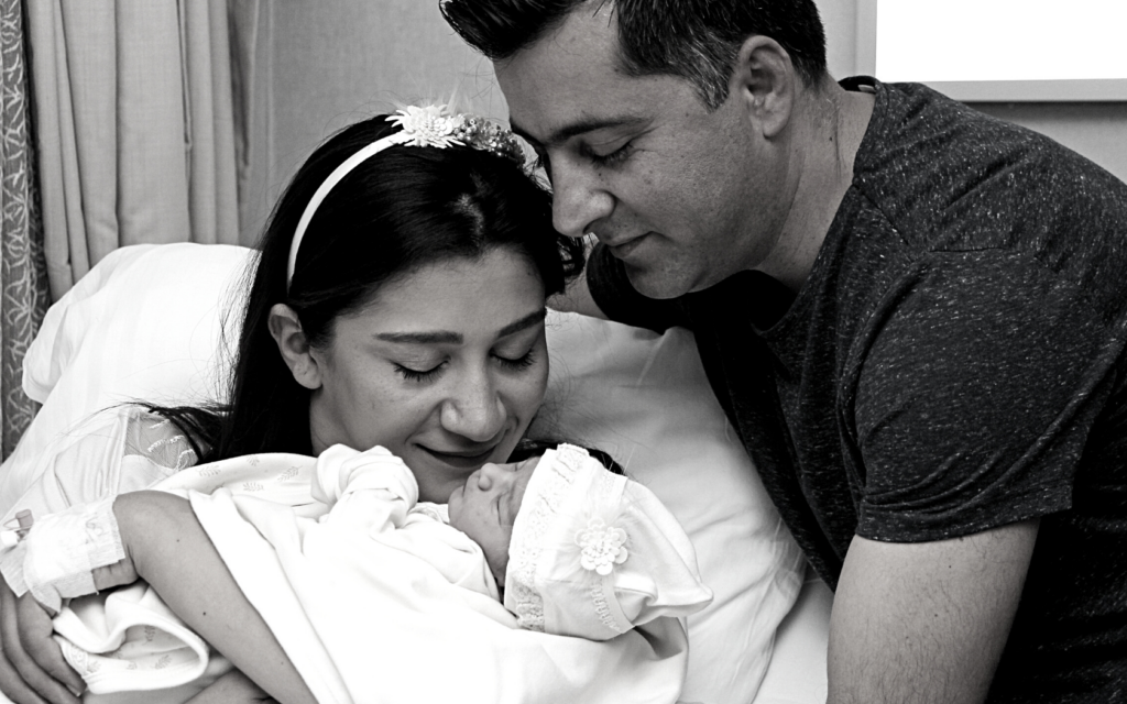 Parents hold their newborn after delivery.