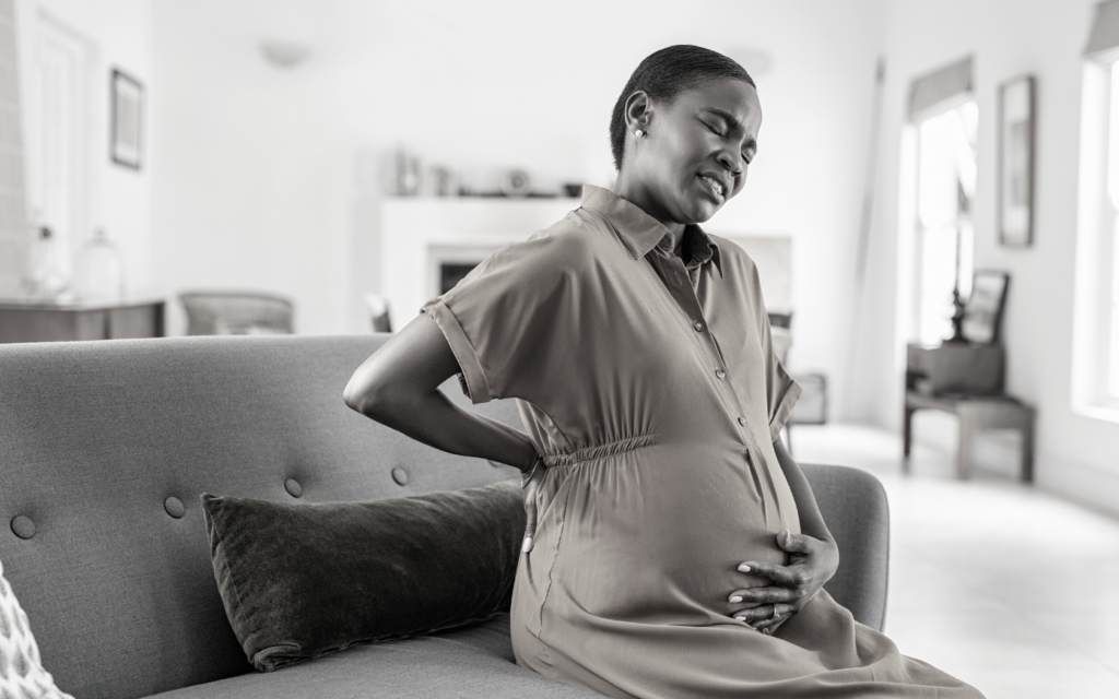Black mother cradles her pregnant belly.