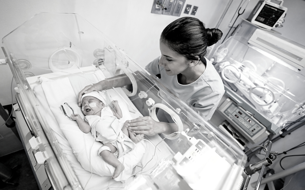 Mother comforts baby in NICU.