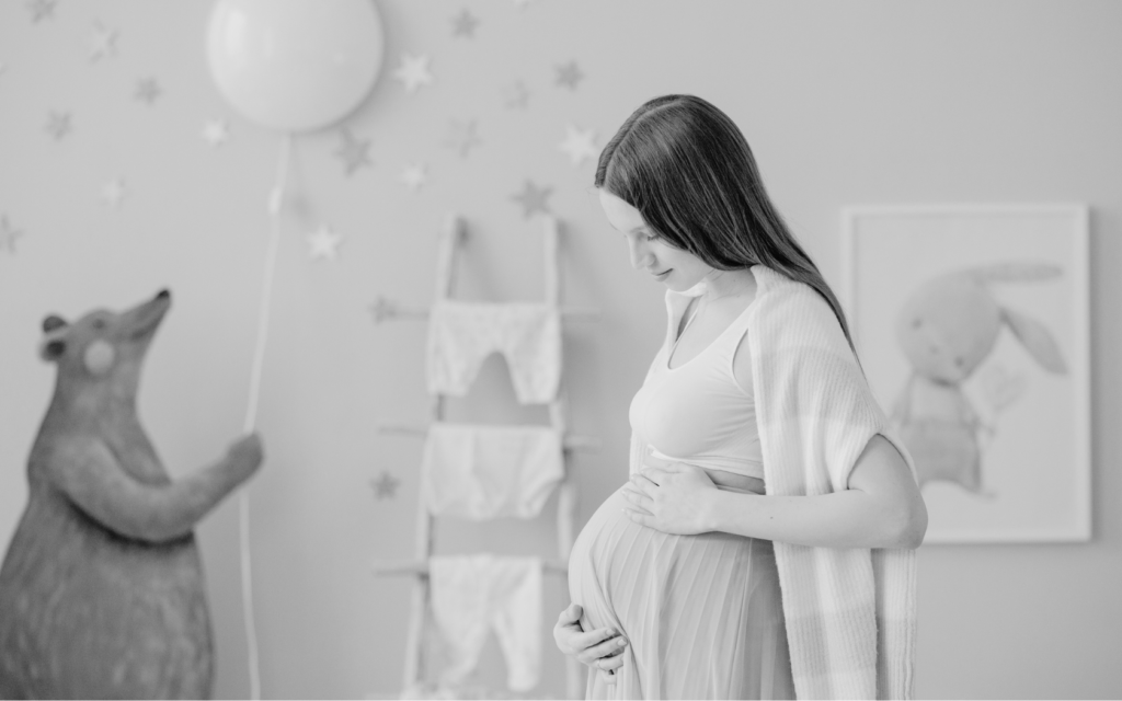 Young mother cradles her pregnant stomach.