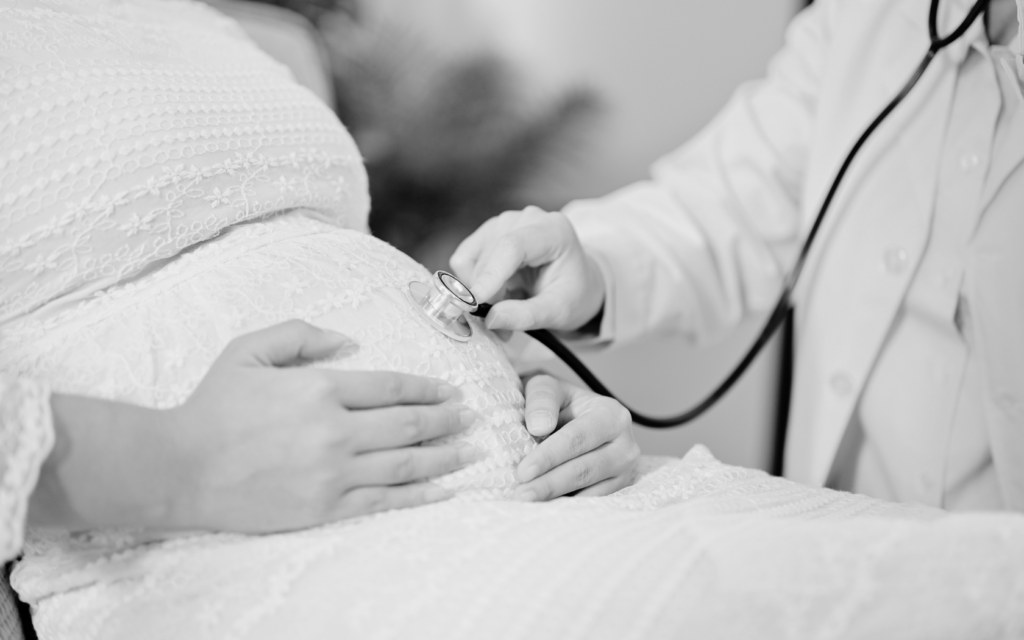 Doctor monitors mother and baby.