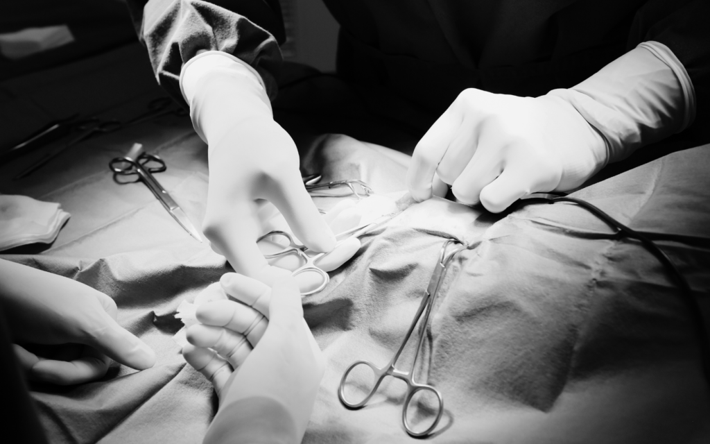 Surgeons in an operating room, surrounded by an array of surgical instruments.