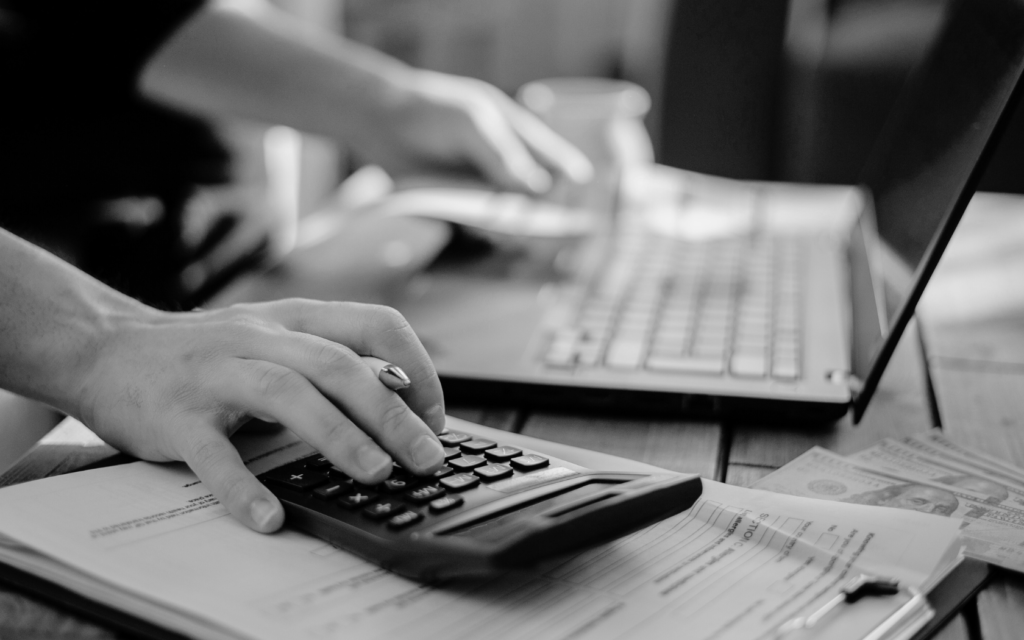 Person using a calculator to estimate lawsuit costs.