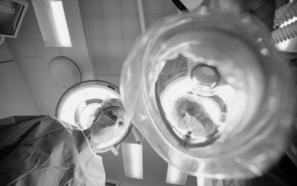 An anesthesiologist fitting an oxygen mask onto a patient before surgery.