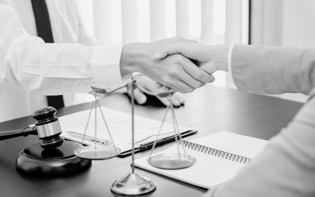 A woman and her lawyer shake hands.