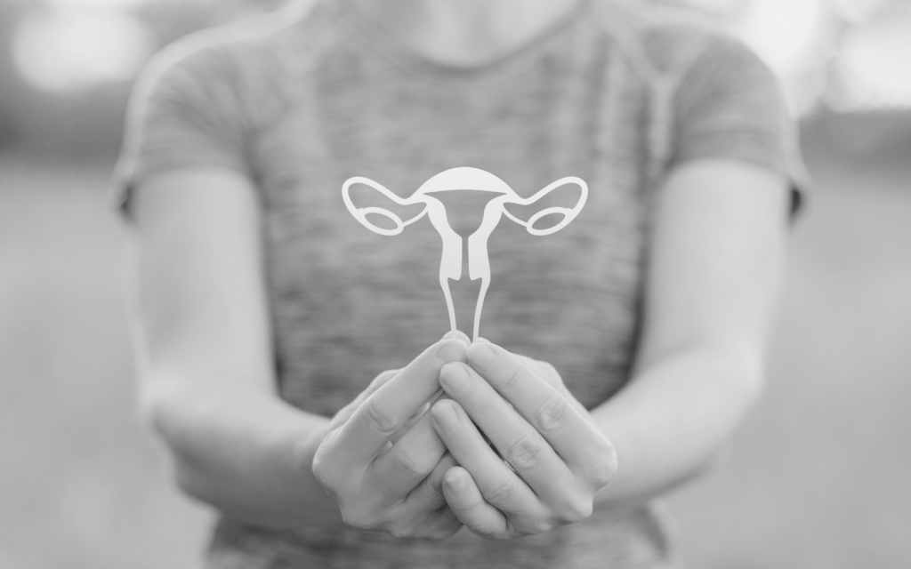 An empowered woman holds an image of a uterus, highlighting the link between uterine fibroids and hair relaxers,