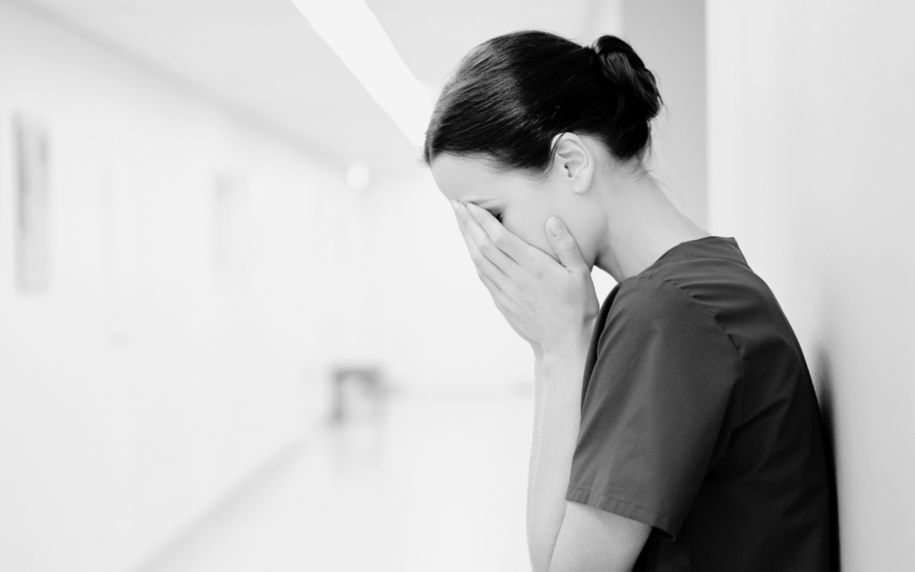 Devastated doctor sitting with head in hands.