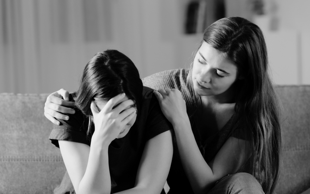Young woman comforting her grieving mother after a loved one’s medical negligence death.