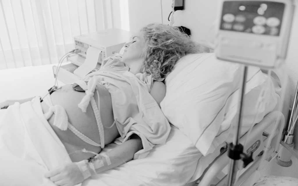 Woman going through a difficult labor, looking exhausted.