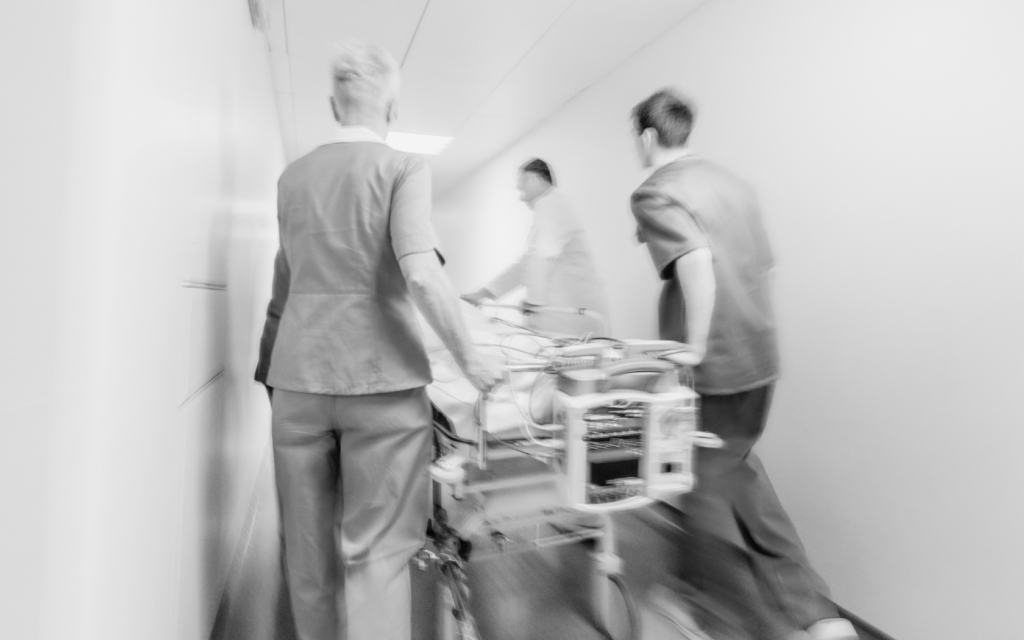 Medical staff rushing pregnant woman into the operating room.