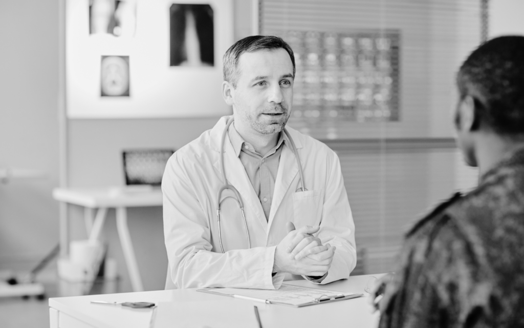 A doctor in a white coat explaining a possible medical error to a patient.